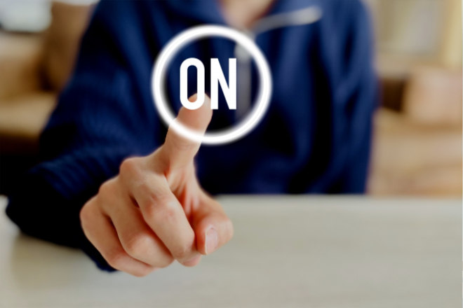 破り取ったカレンダーの紙を手に持ち、窓の外を眺める女性