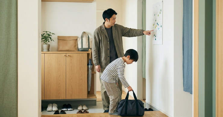 学校や外出に必要な物を玄関で準備する日本人家族